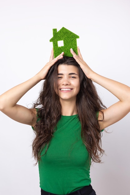 Szczęśliwy kupujący dom Młoda dziewczyna trzyma w rękach model zielonego domu Koncepcja ekologii zielonej energii