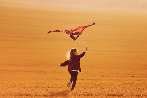 Szczęśliwy mała dziewczynka bieg z kanią w rękach na pięknym polu