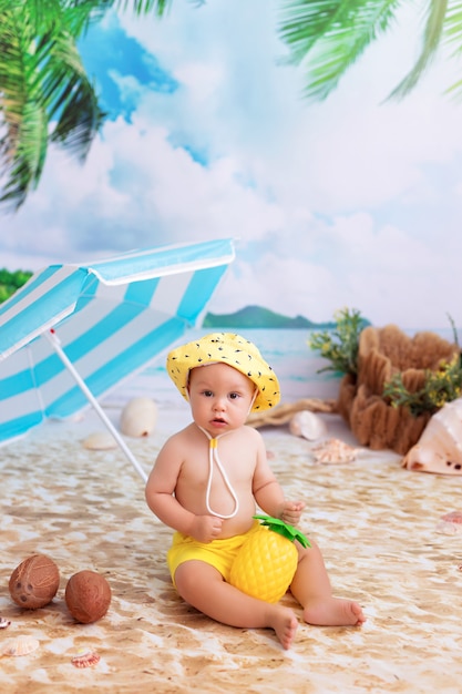 Szczęśliwy Mały Chłopiec Opalając Się Na Piaszczystej Plaży Nad Morzem Z Palmami Pod Parasolem
