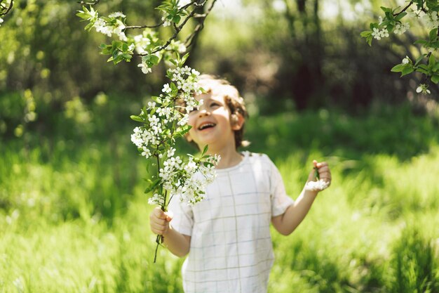 Szczęśliwy mały chłopiec spacerujący po wiosennym ogrodzie