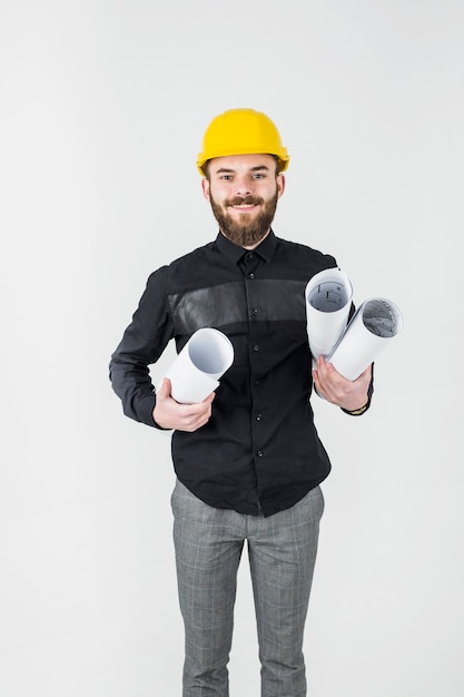 Zdjęcie szczęśliwy męski budowniczego architekta mienia projekt przeciw białemu tłu