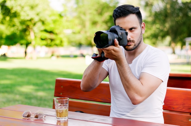 Szczęśliwy męski turysta bierze fotografie przy kawiarnią.