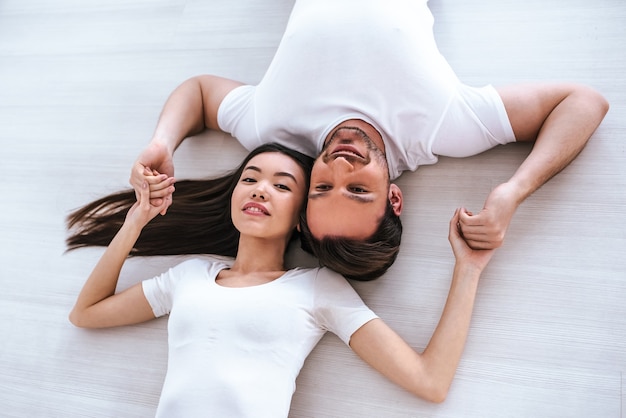 Szczęśliwy mężczyzna i kobieta leżą na podłodze