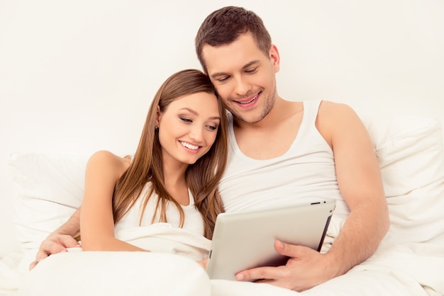 Szczęśliwy mężczyzna i kobieta w miłości do czytania wiadomości na tablecie