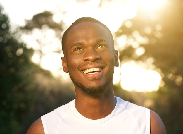 Szczęśliwy młody amerykanin afrykańskiego pochodzenia mężczyzna ono uśmiecha się outdoors