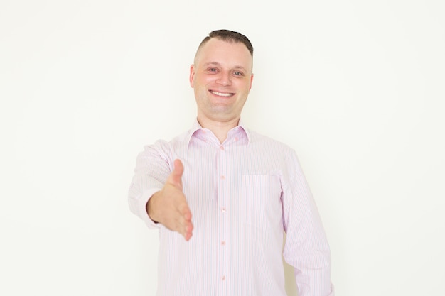 szczęśliwy młody biznesmen Kaukaski na sobie pasiastą koszulę wyciągając rękę na powitanie
