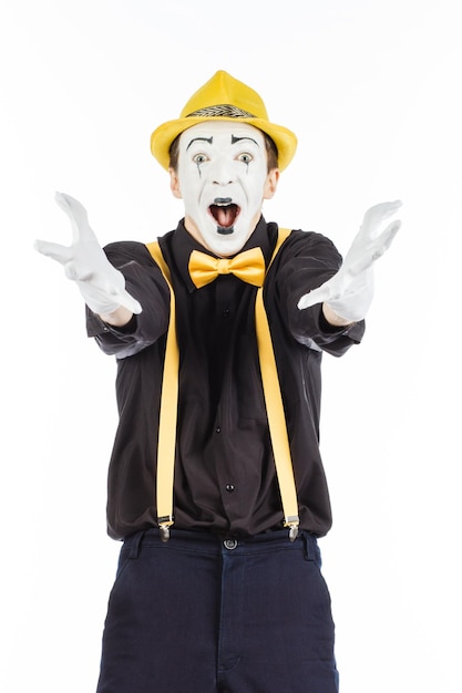 Zdjęcie szczęśliwy młody człowiek aktor pantomima raduje się sukcesem na białym tle