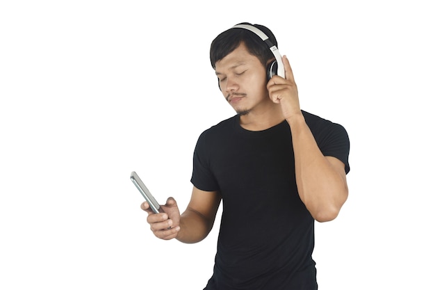 Szczęśliwy młody człowiek słuchający muzyki w słuchawkach na białym tle kopii przestrzeni