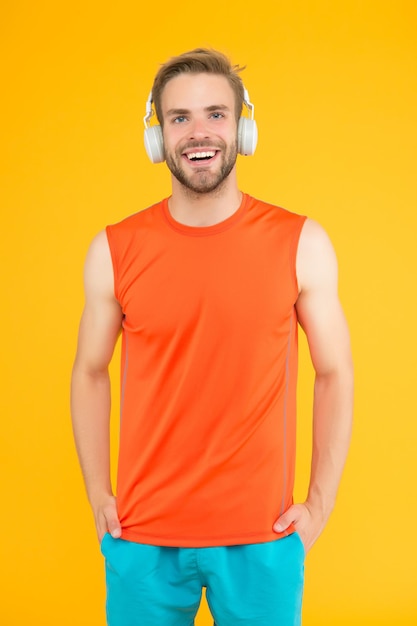 Szczęśliwy młody człowiek sportowiec w sporcie nosić i zestaw słuchawkowy słuchać muzyki podczas ćwiczeń, fitness i muzyki.
