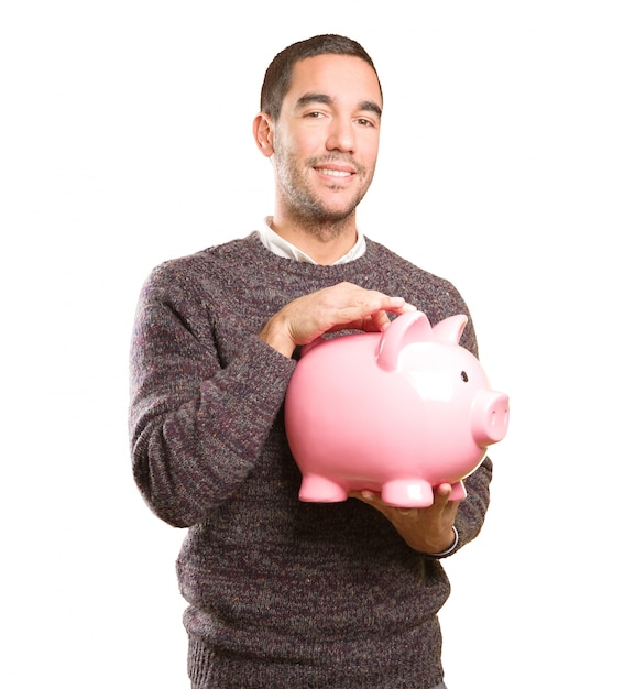 Szczęśliwy młody człowiek trzyma piggy bank
