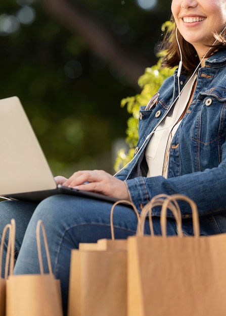 Zdjęcie szczęśliwy nastolatek trzymając laptopa na zewnątrz