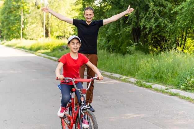 szczęśliwy ojciec cieszy się, że jej córka nauczyła się jeździć na rowerze.