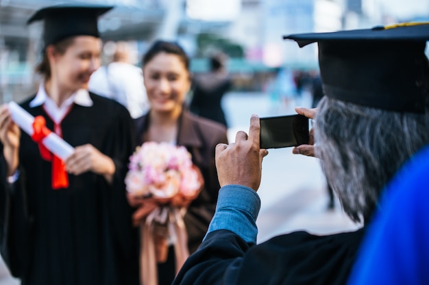 szczęśliwy ojciec i córka w suknie ukończeniu co selfie.