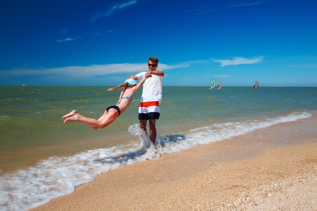 Szczęśliwy ojciec i jego córka na plaży zabawy.