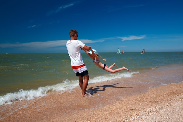 Szczęśliwy ojciec i jego córka na plaży zabawy.