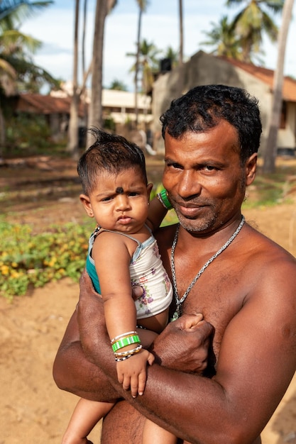 Szczęśliwy ojciec z małym dzieckiem w ramionach. Szczęśliwa rodzina . Sri Lanka.