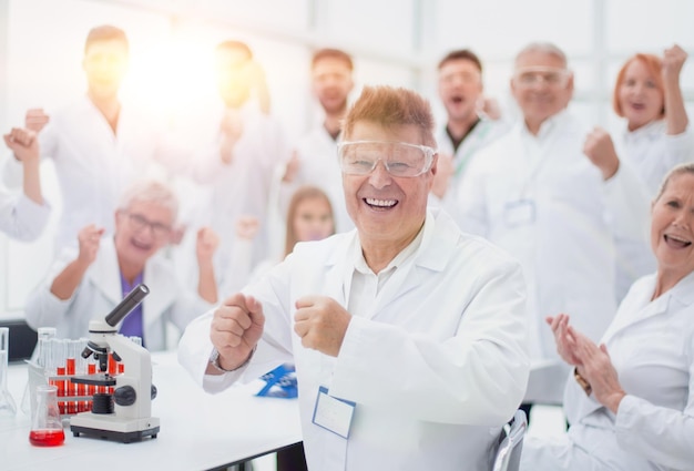 szczęśliwy opiekun naukowy i jego grupa robocza w miejscu pracy. koncepcja sukcesu.