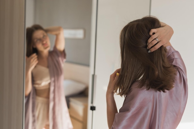 Szczęśliwy poranek Atrakcyjna młoda kobieta patrząca w lustro na swoje mieszkanie