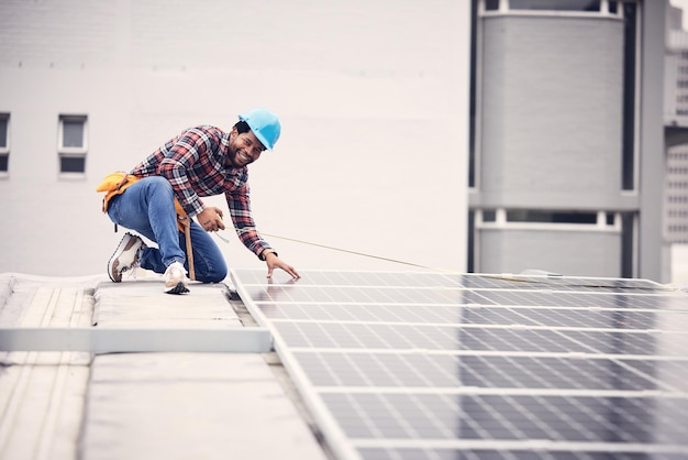 Szczęśliwy portret mężczyzny panel słoneczny i taśma miernicza do zrównoważonej energii elektrycznej z sieci fotowoltaicznej lub energii odnawialnej Kontrola jakości dachu Afrykańska złota rączka i konserwacja zasilania