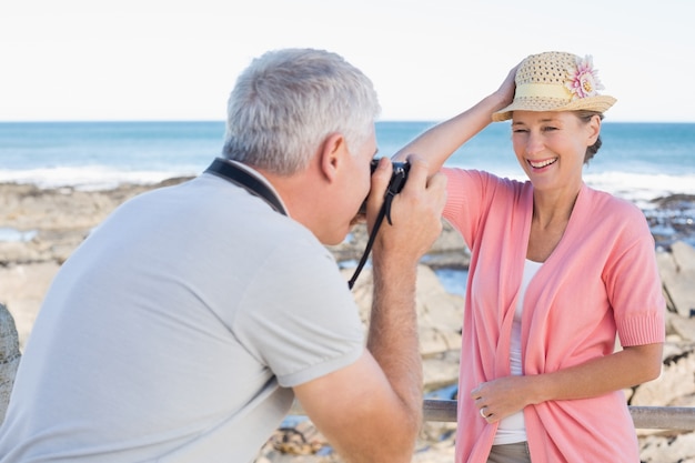 Szczęśliwy przypadkowy mężczyzna bierze fotografię partner morzem