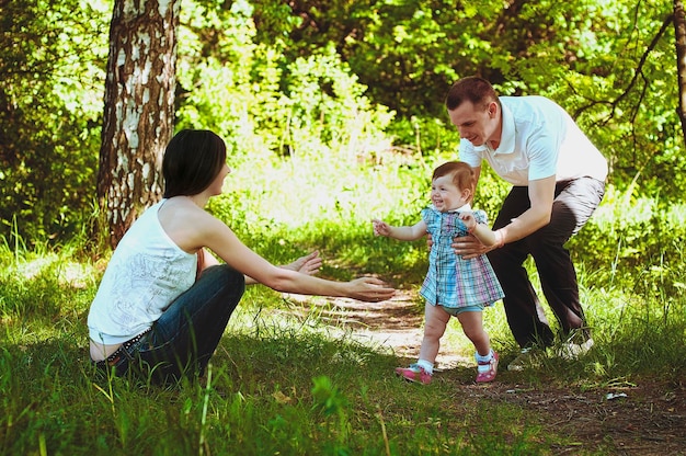 Szczęśliwy, rodzinny styl życia i wakacje. Matka, ojciec, mała dziewczynka spaceru w mieście, zielony park. Zabawa