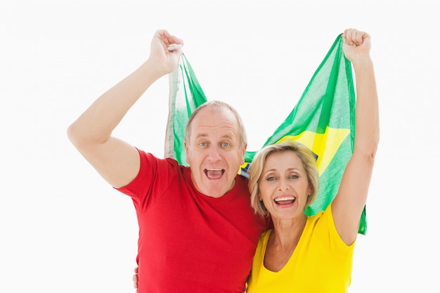 Szczęśliwy starszy para doping przy kamerą trzyma Brazil flaga