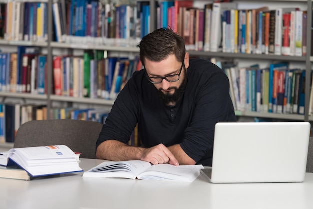 Szczęśliwy Student Z Laptopem W Bibliotece