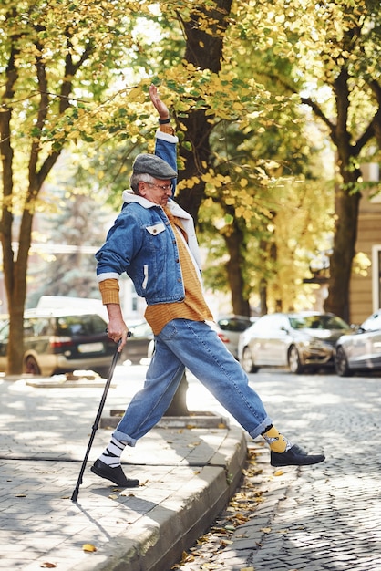 Szczęśliwy Stylowy Senior W Modnych Ubraniach I Okularach Spaceruje I Cieszy Się życiem.