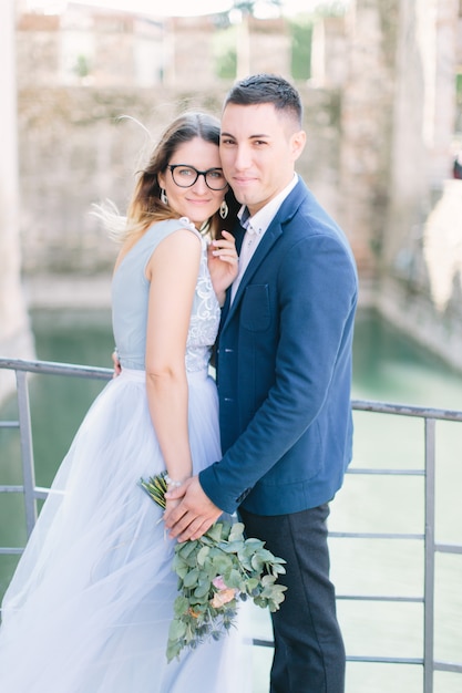 Szczęśliwy stylowy uśmiechnięty pary odprowadzenie w Sirmione, Włochy w ich dniu ślubu