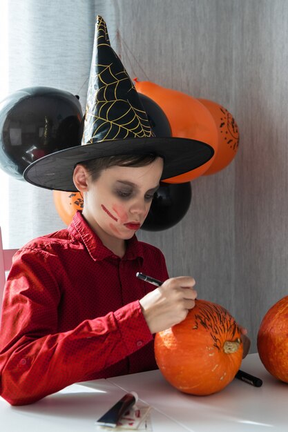 Szczęśliwy Teen Chłopiec W Kostiumie Przygotowuje Się Do Obchodów Halloween Rysowanie Dyni