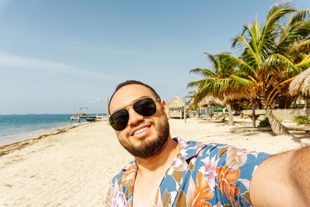 Szczęśliwy turysta robiący selfie na plaży Guanaja Honduras Koncepcja turystyczna