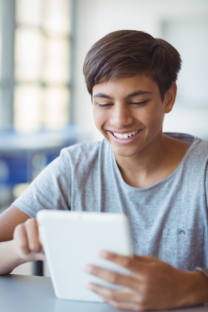 Szczęśliwy uczeń za pomocą cyfrowego tabletu w klasie