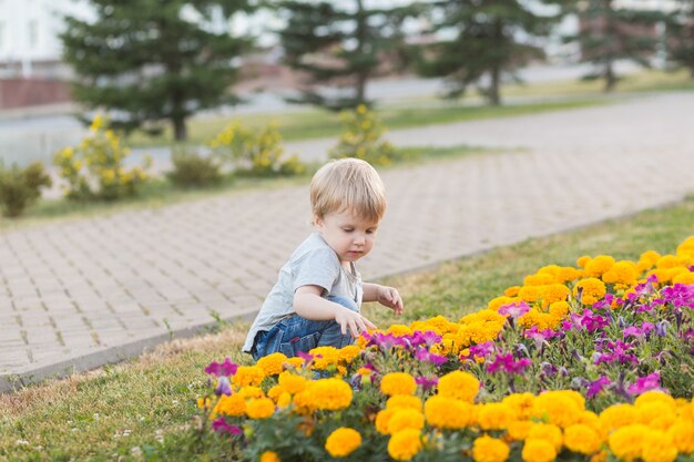 Szczęśliwy uśmiech malucha chłopiec spaceru w parku na zewnątrz