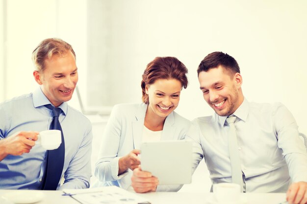 Zdjęcie szczęśliwy zespół biznesowy bawiący się komputerem typu tablet w biurze