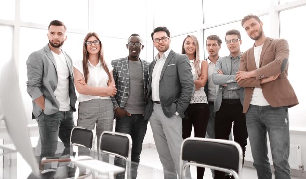 Szczęśliwy zespół biznesowy stojący na jasnym zdjęciu biurowym z miejscem na kopię