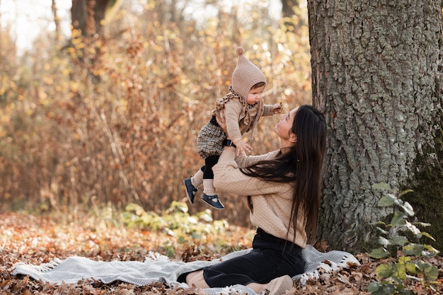 Szczęśliwych potomstw macierzysty bawić się z małą dziecko córką w jesień parku