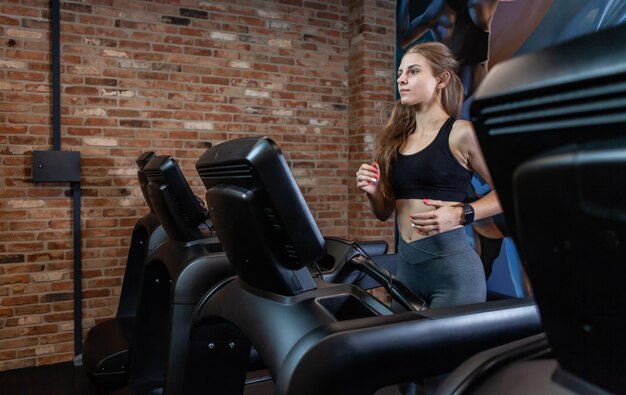 Szczupła Piękna Kobieta Robi Trening Cardio Na Bieżni, ćwiczy Na Siłowni