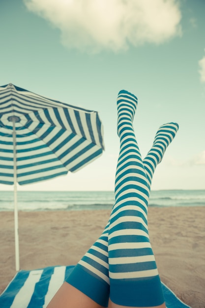 Szczupłe nogi kobiety na plaży. Letnie wakacje i koncepcja podróży. Retro