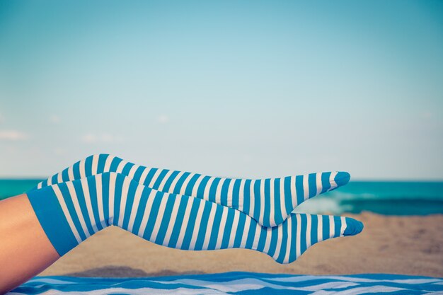 Szczupłe nogi kobiety na plaży. Letnie wakacje i koncepcja podróży