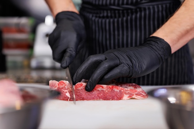 Szef kuchni cięje żebra wieprzowe w kuchni restauracji.