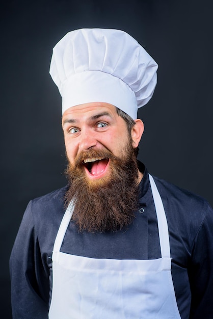 Szef kuchni gotowy do gotowania nowego dania brodaty mężczyzna w mundurze szefa kuchni kucharz lub piekarz w białym kapeluszu i