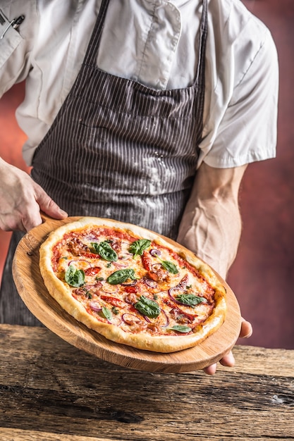 Szef kuchni i pizza. Szef kuchni oferujący pizzę w hotelu lub restauracji