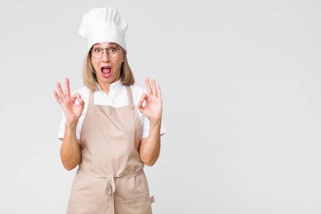 szef kuchni kobieta czuje się zaskoczony, pokazując znak zatwierdzenia obiema rękami