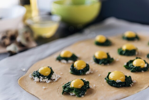 Szef kuchni krok po kroku przygotowuje ravioli z serem ricotta, żółtkami przepiórczymi i szpinakiem z przyprawami. Szef kuchni przygotowuje nadzienie na cieście