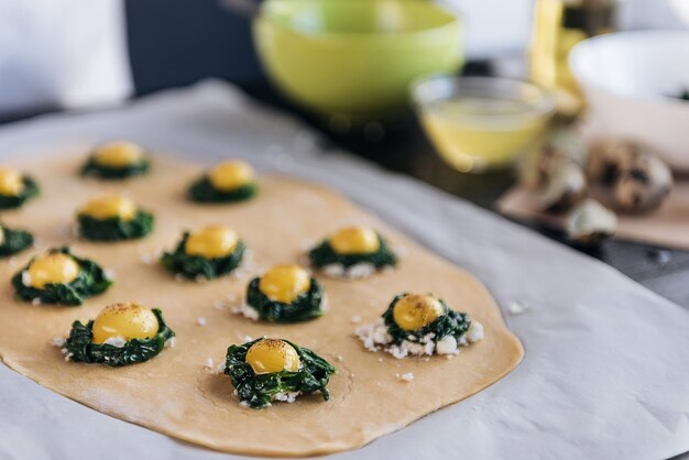 Szef kuchni krok po kroku przygotowuje ravioli z serem ricotta, żółtkami przepiórczymi i szpinakiem z przyprawami. Szef kuchni przygotowuje nadzienie na cieście