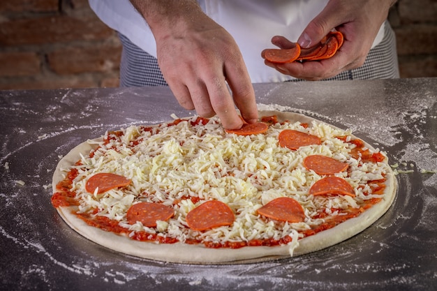Zdjęcie szef kuchni przygotowuje ciasto na włoską pizzę