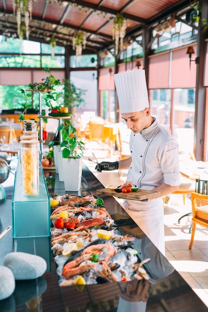 Szef kuchni stawia owoce morza na tacy w restauracji.