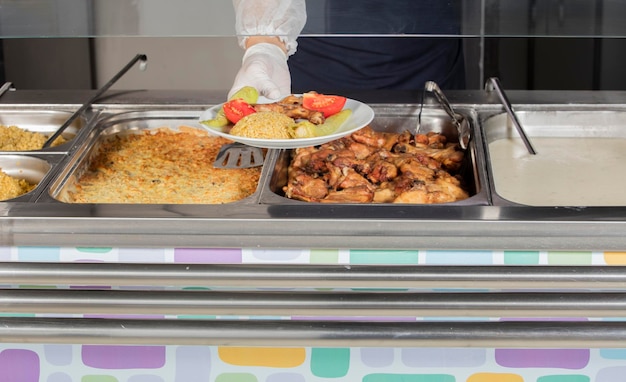 Szef kuchni stojący za pełną stacją na lunch