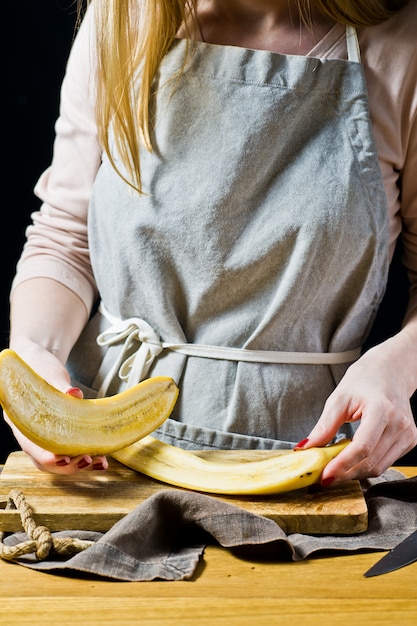 Szef kuchni tnie banana na plasterki. Gotowanie pieczonych bananów.