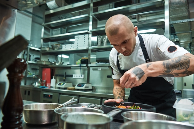 Szef Kuchni Z Kilkoma Tatuażami Na Ramionach Ozdabiający Makaron Carbonara W Kuchni Restauracji